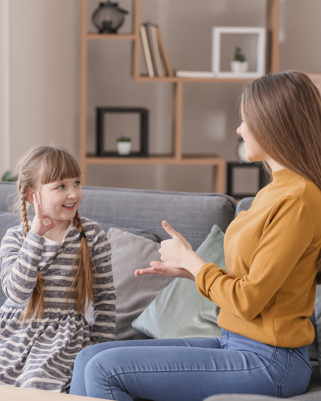 Mother and young child practicing baby sign language together at home