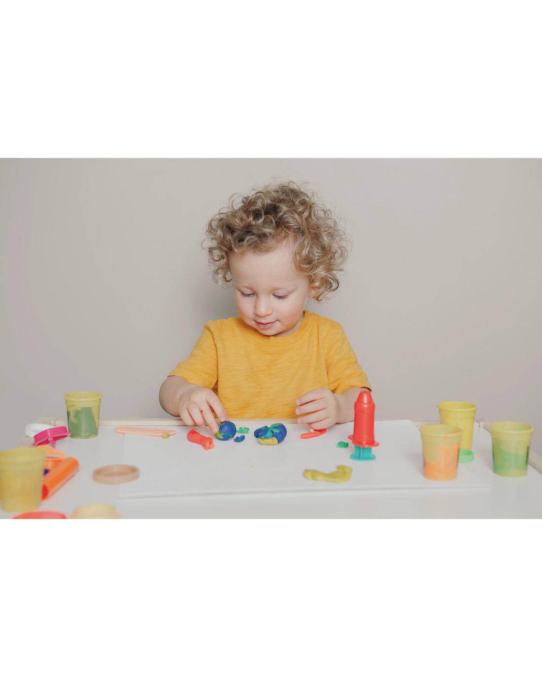 Toddler exploring a simple hands-on activity with sensory materials in warm natural light