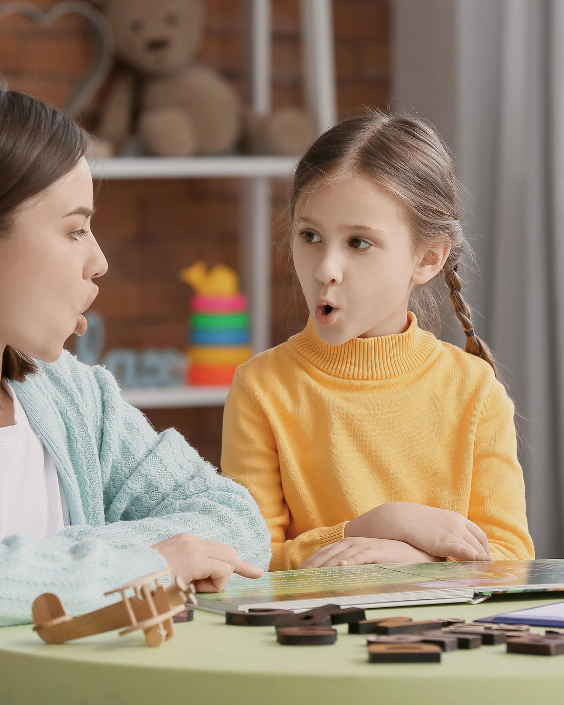 Speech therapist working with a young girl in a clinic