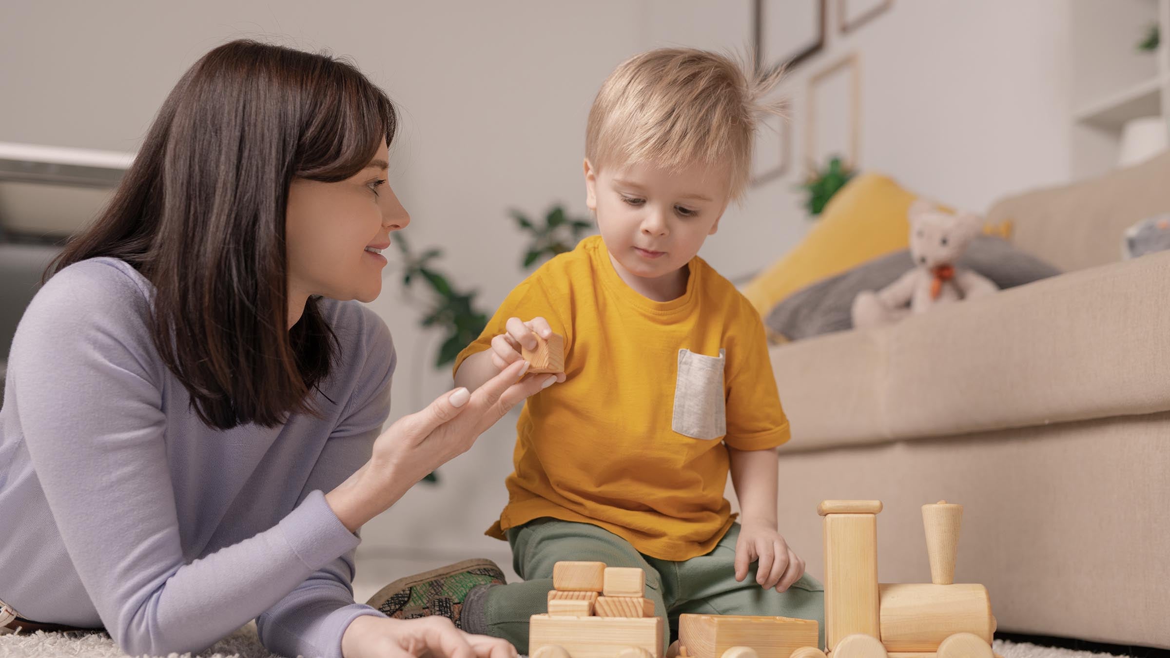 Parent and toddler stacking wooden counting blocks together at home
