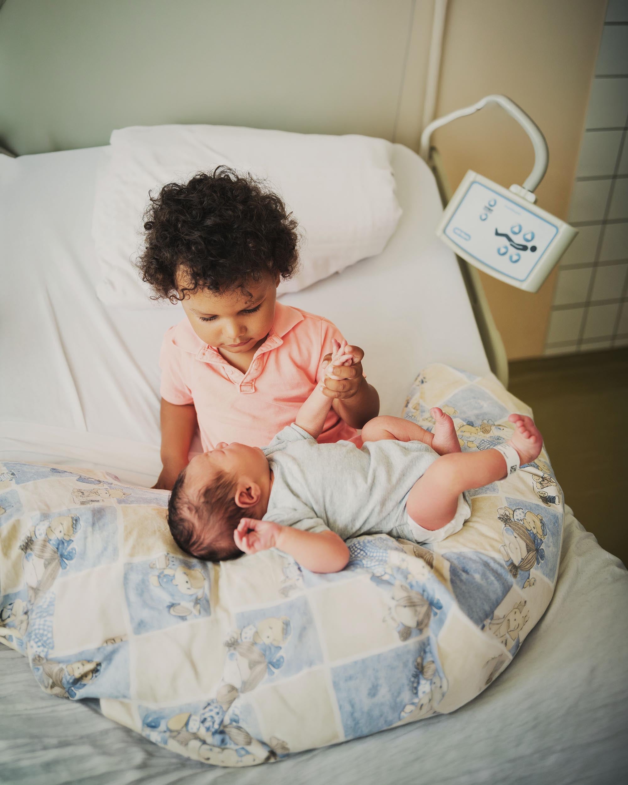 Toddler meeting his newborn brother for the first time