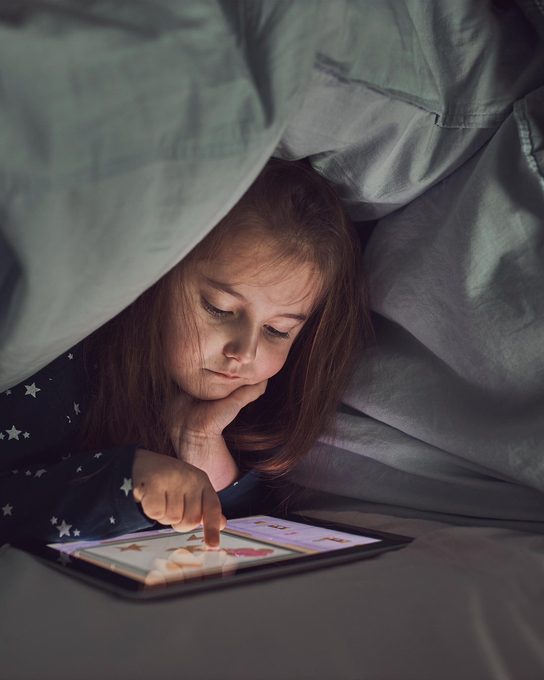 Little girl watching stories on a tablet