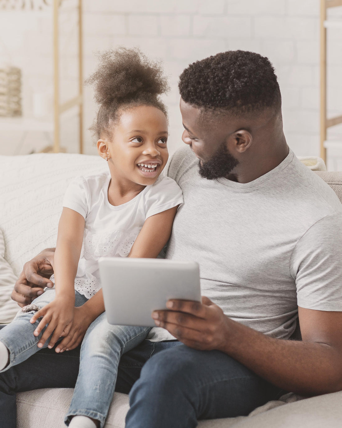 Father and daughter watching cartoons together on a tablet