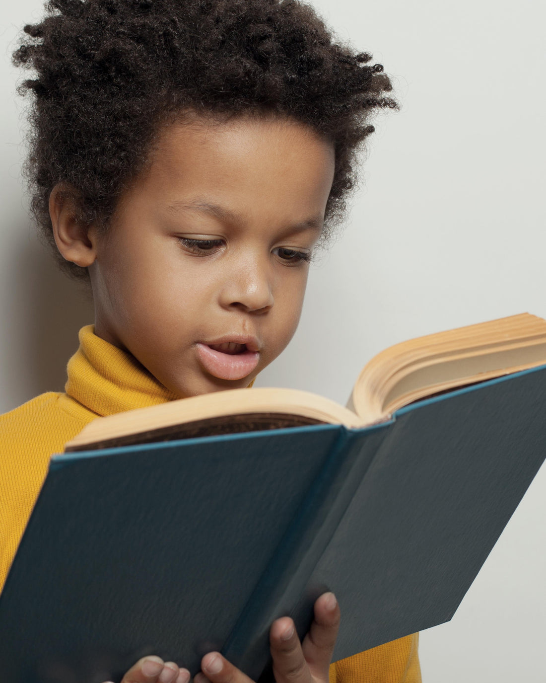 Young child reading a book independently