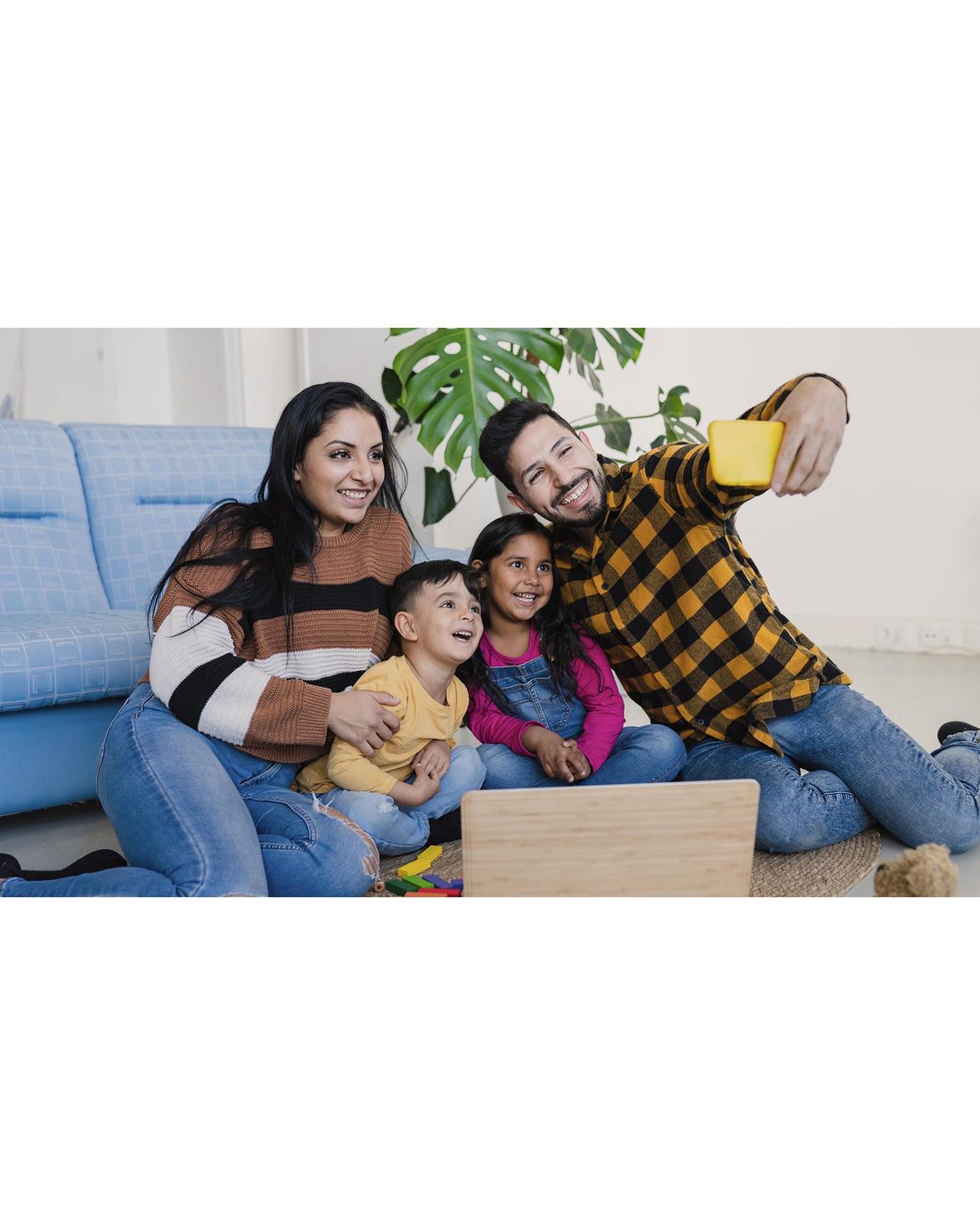 Family with two children taking a selfie together at home