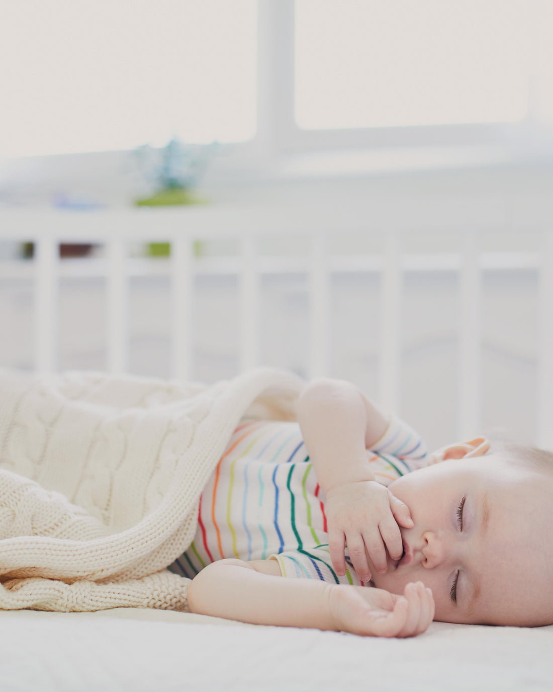 Baby sleeping peacefully in a co-sleeper crib