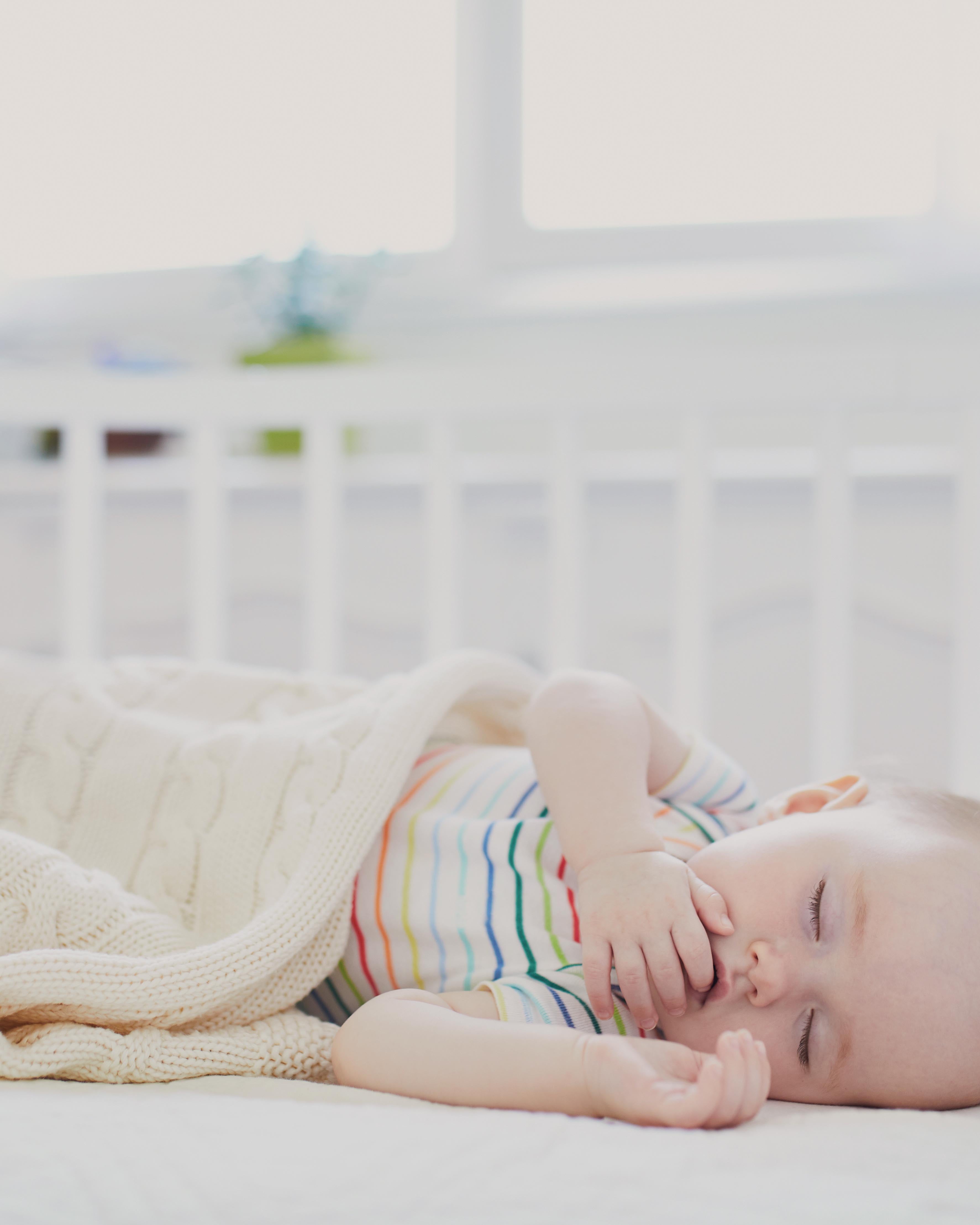 Baby sleeping peacefully in a co-sleeper crib