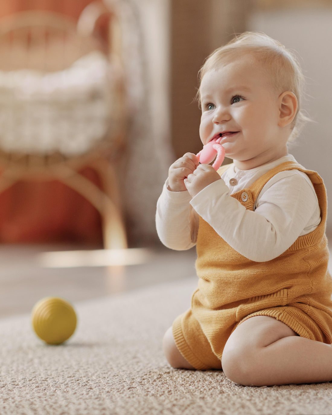 Baby biting a teething toy while playing