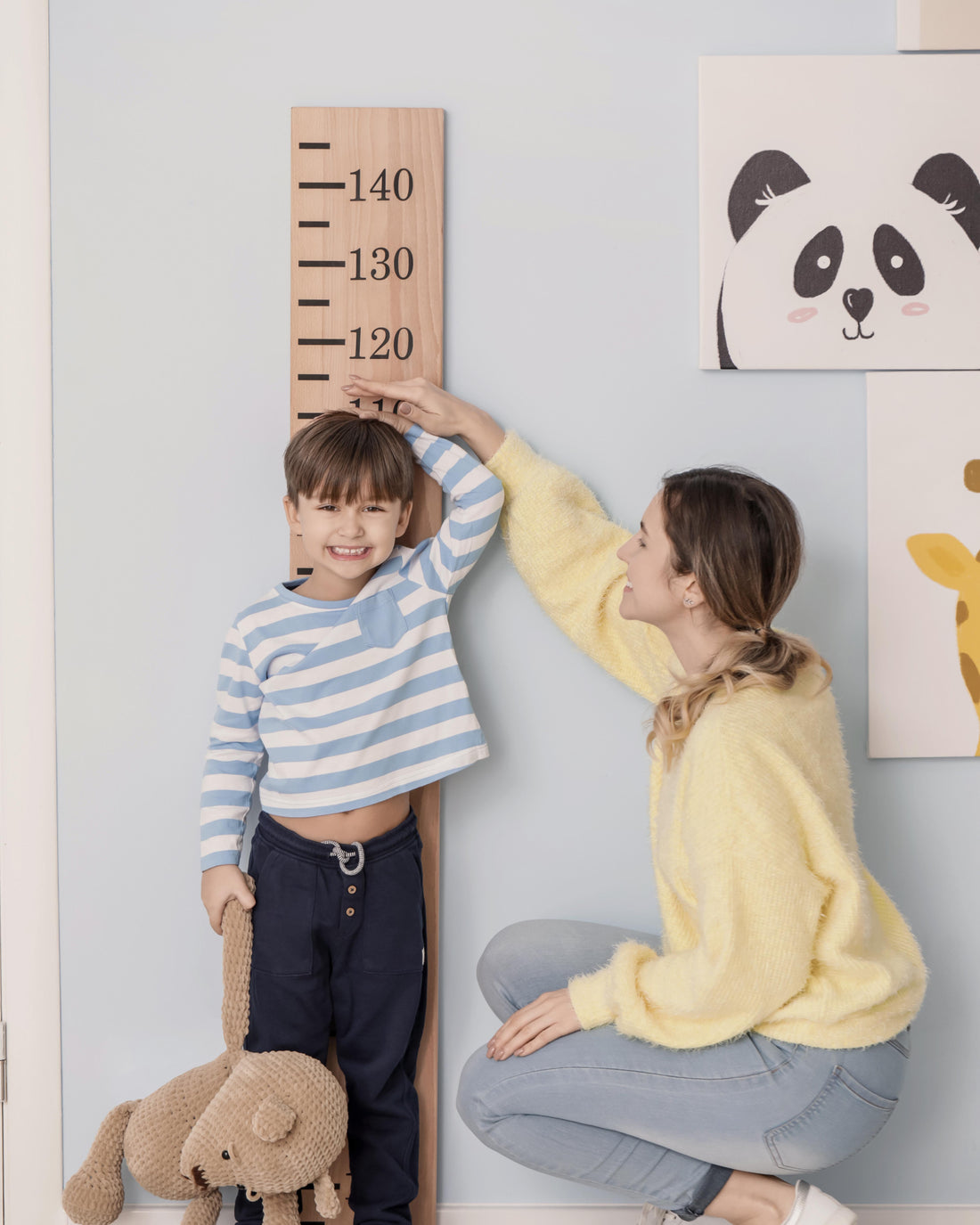 Mother measuring her son's height growth at home