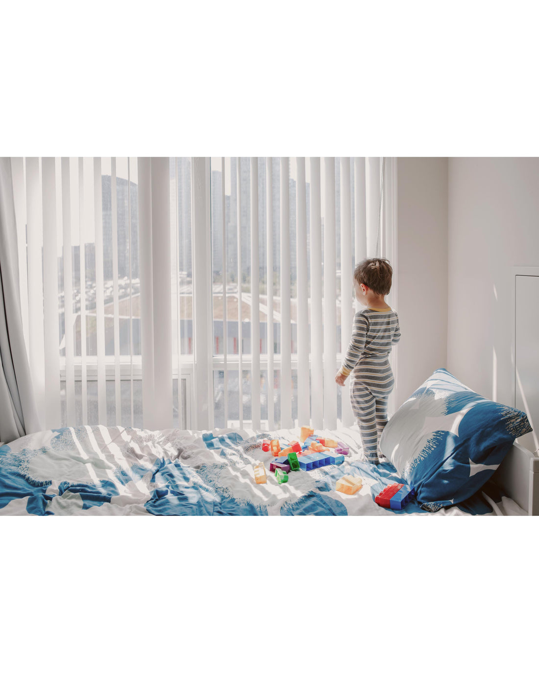 Toddler looking out the window daydreaming