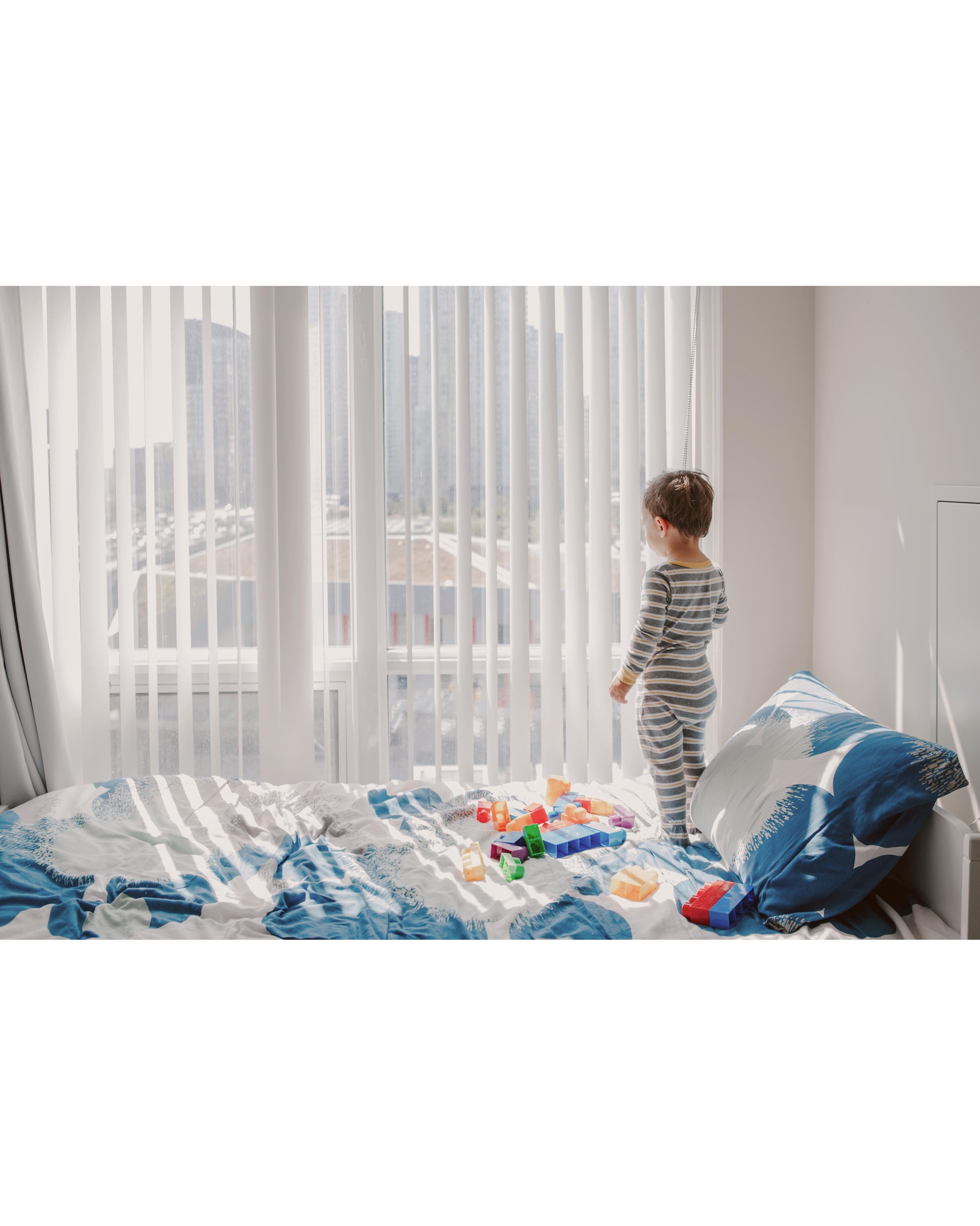Toddler looking out the window daydreaming