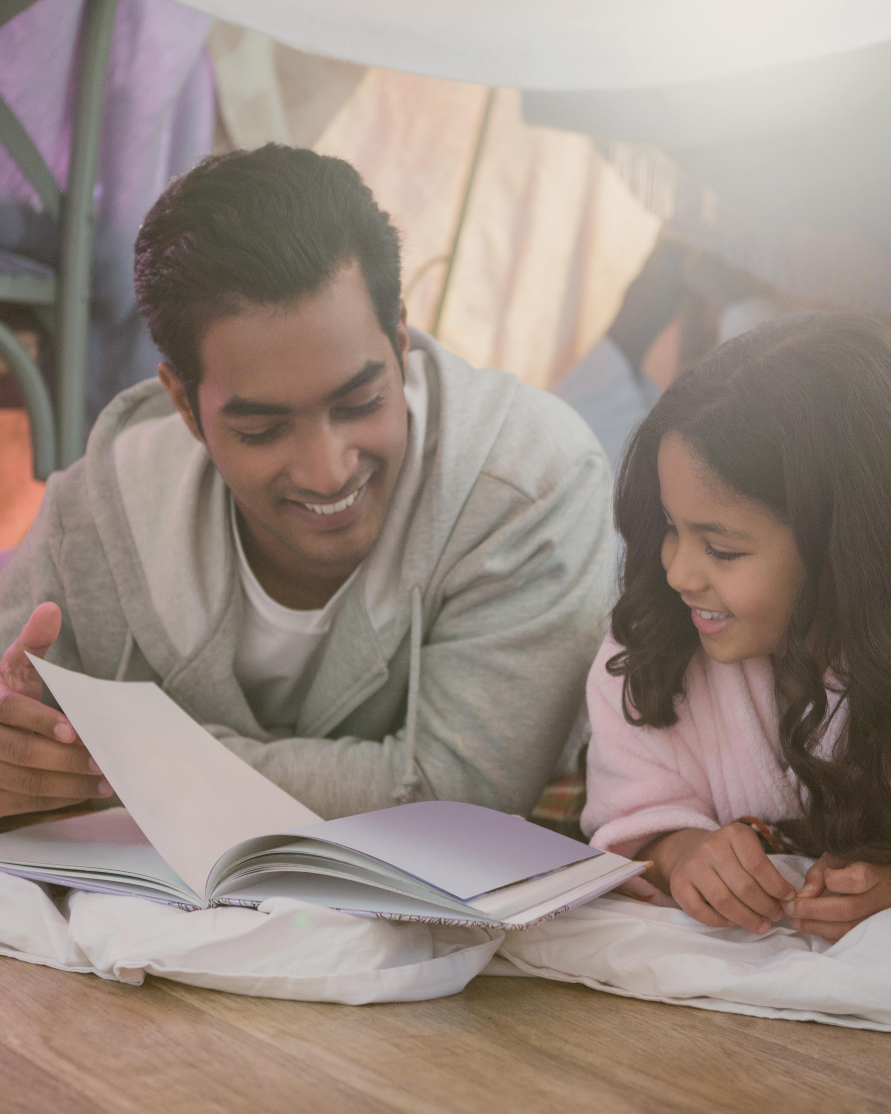 Father and daughter reading a book together