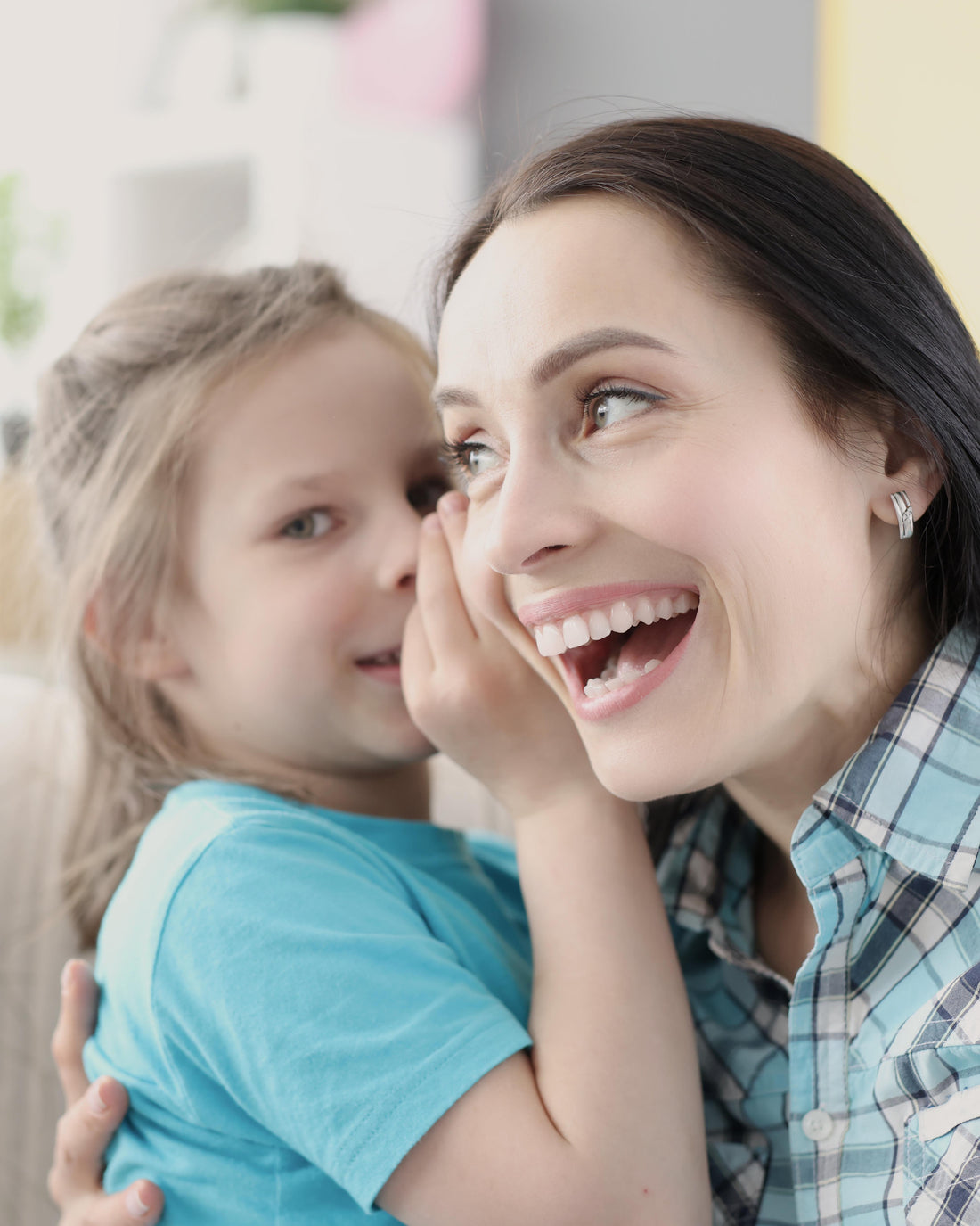 Little girl whispering to her mom at home