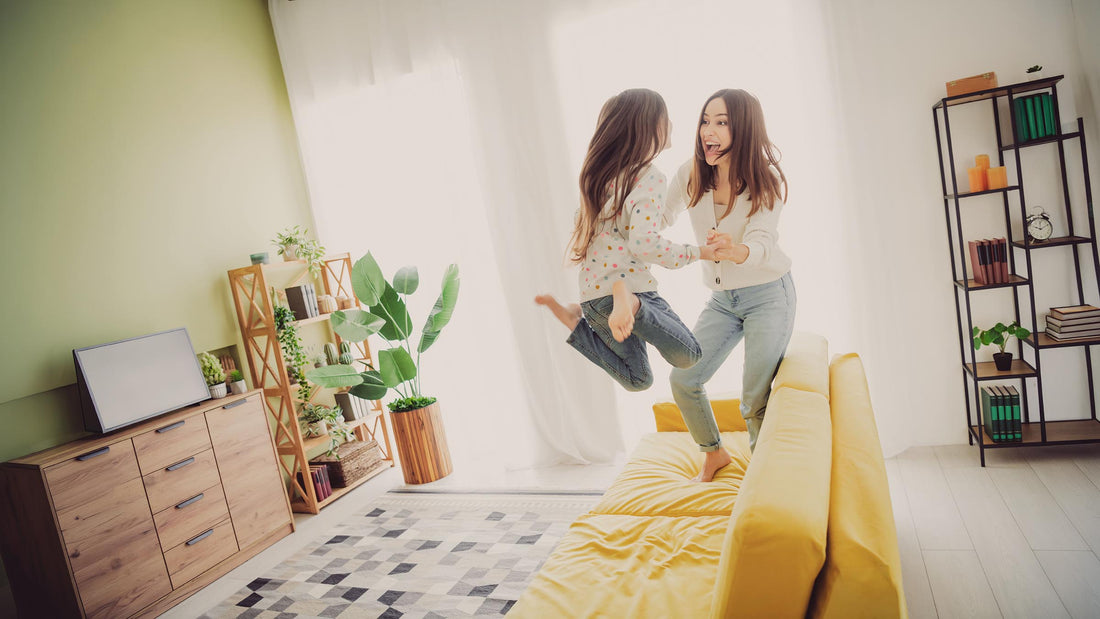 Mother and daughter sharing a joyful moment together on a sunlit couch