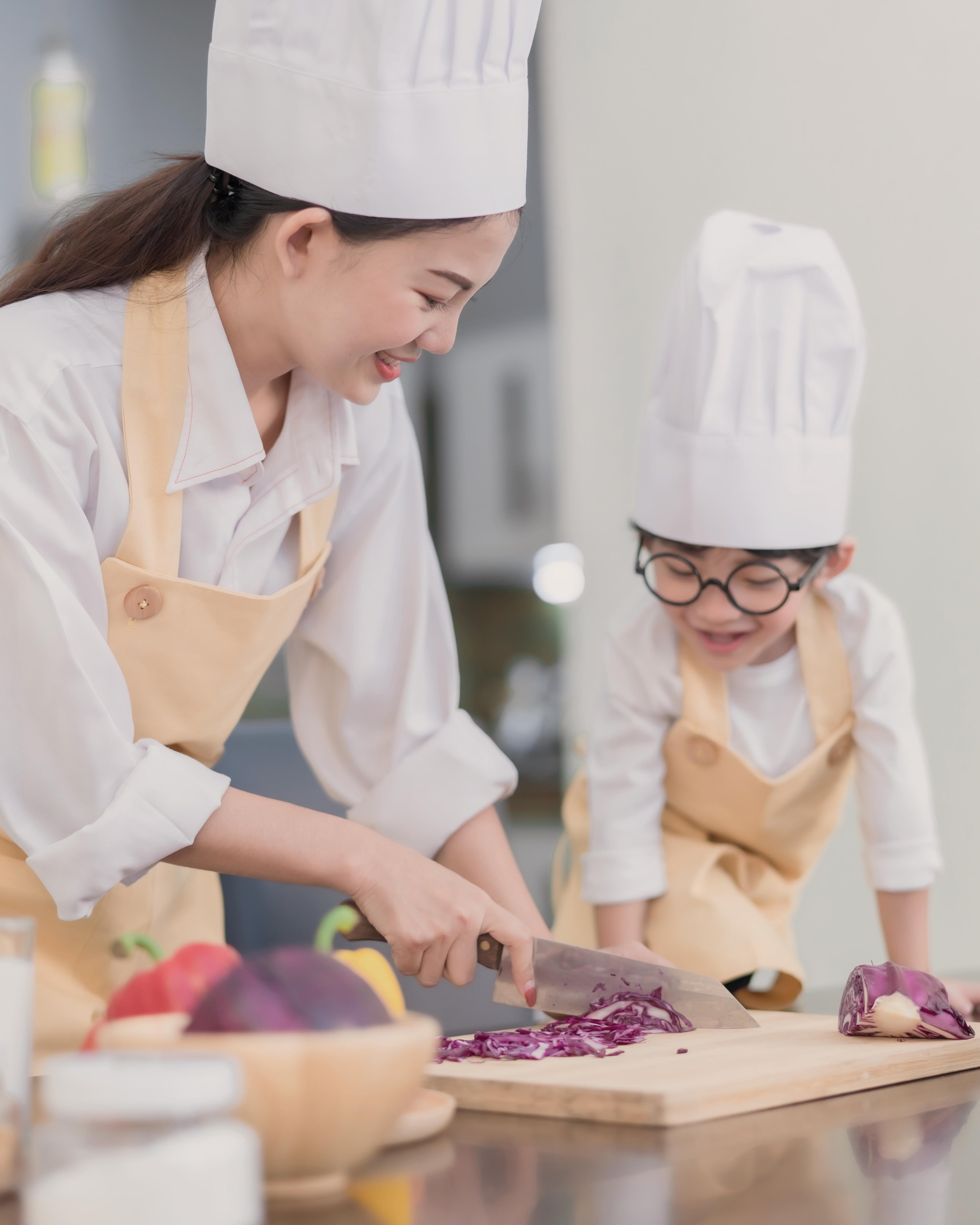 Mother teaching her son to cook in the kitchen