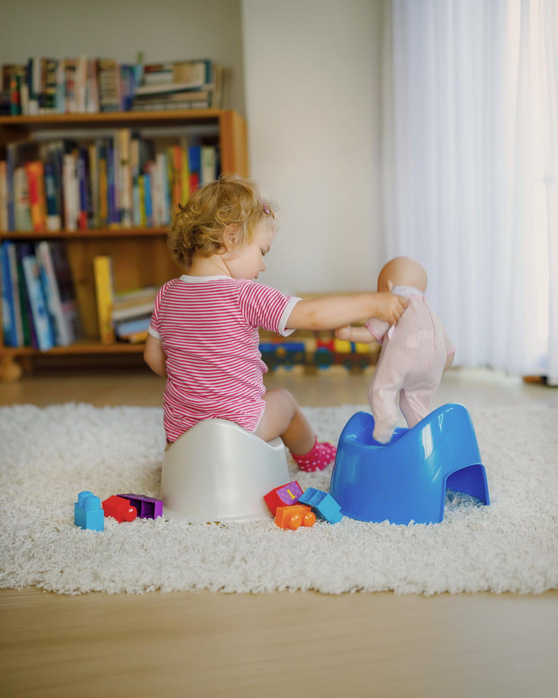 Toddler girl sitting on a potty, potty training