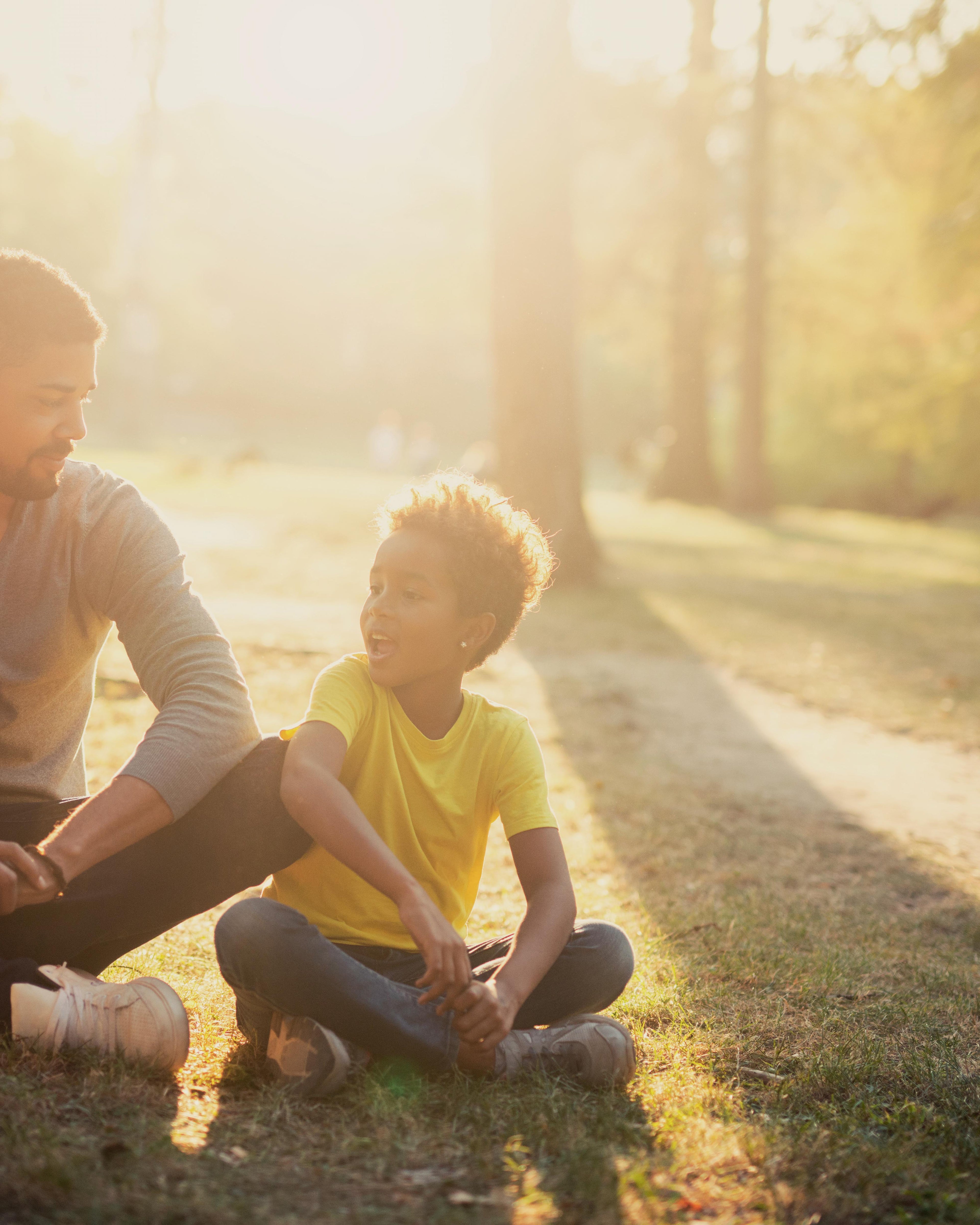 Happy family sitting together in the park at sunset