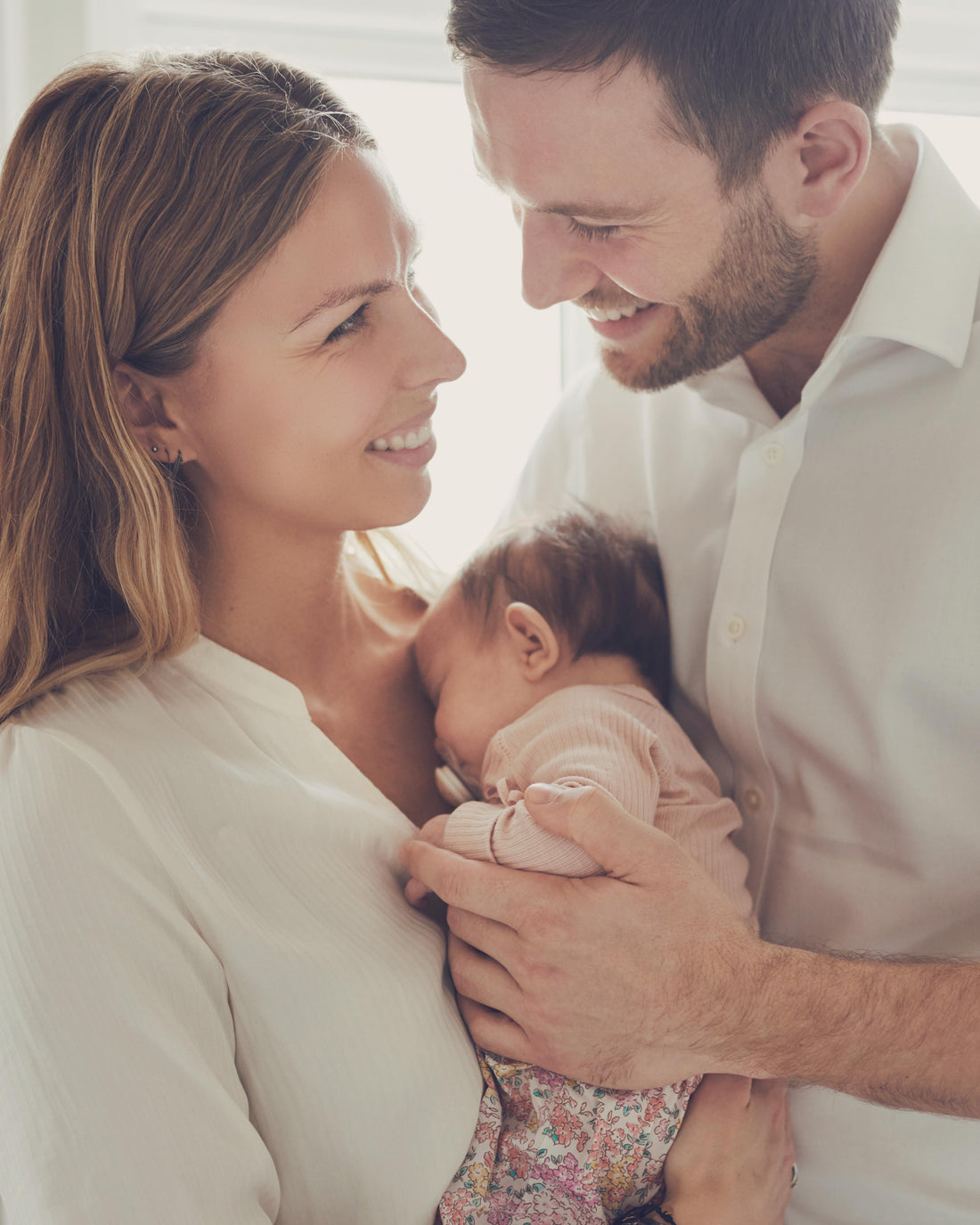 Proud young parents holding their infant daughter at home