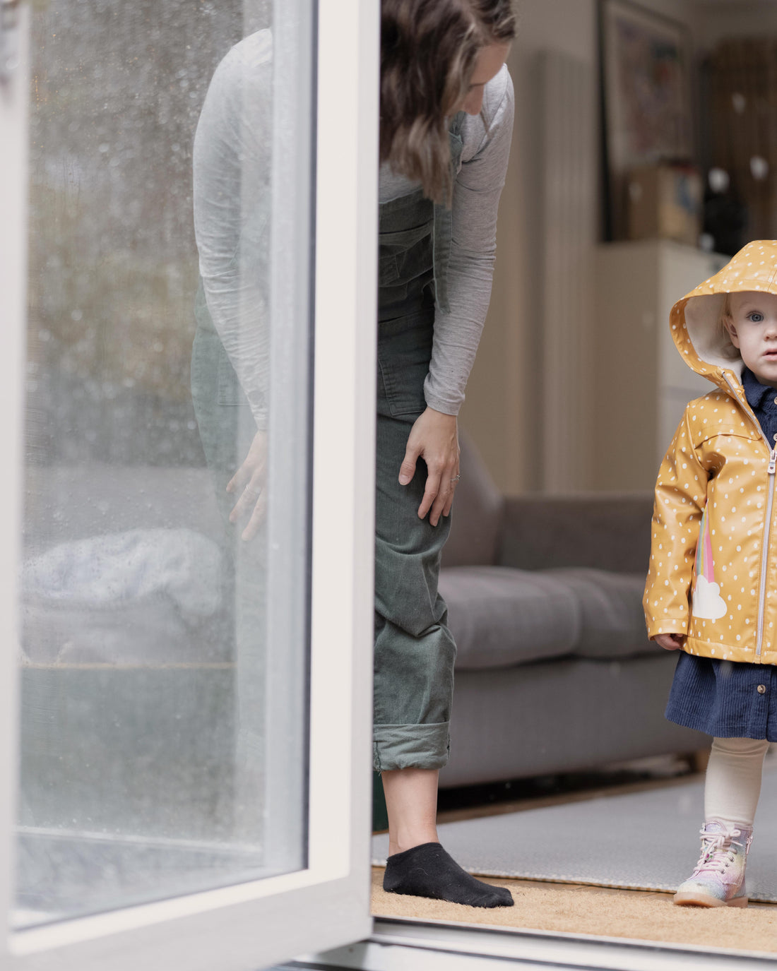 Mother and daughter standing by an open door to the garden