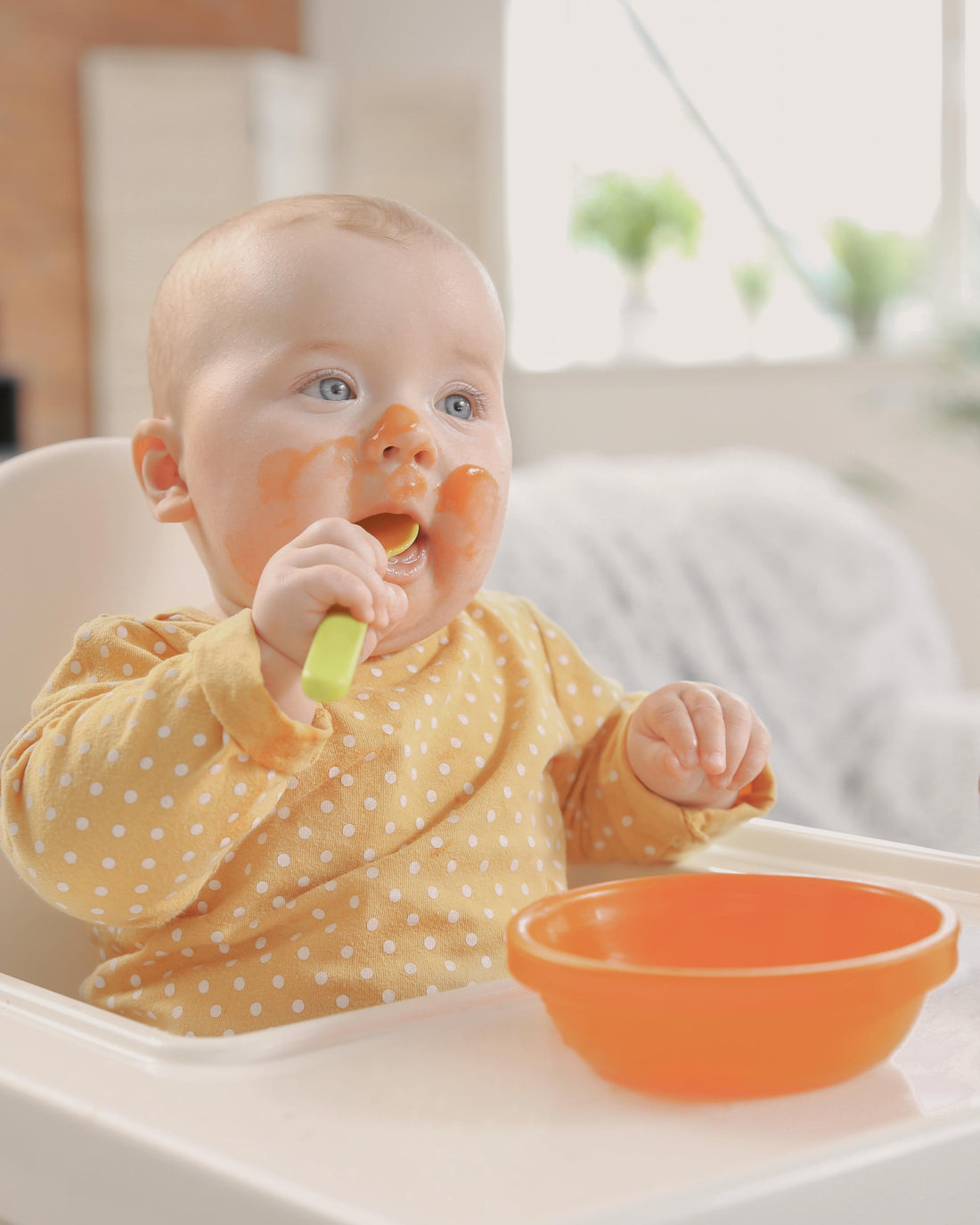 Baby eating food happily at home