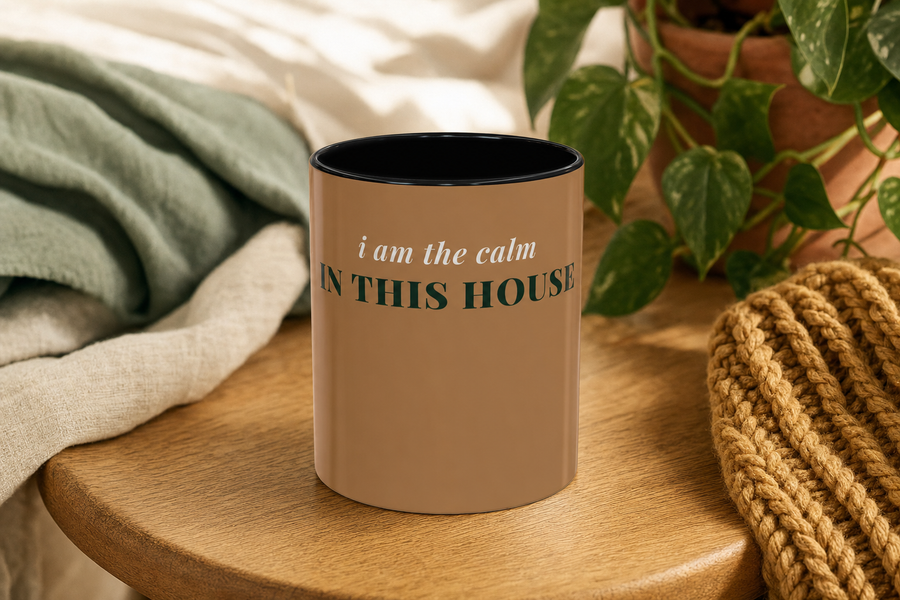 The Calm In This House Coffee Mug by Nureli by Kala Library, ceramic mug styled on a warm oak table in soft morning light, premium lifestyle photo